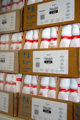 Die Abbildung zeigt mehrere Kartons mit Frischmilchflaschen, auf denen das Produkt "Fresubin 2 kcal" deutlich beschriftet ist. Die Kartons sind ordentlich gestapelt und aufeinander geschichtet, was die Lagerung von Nahrungsmitteln darstellt.